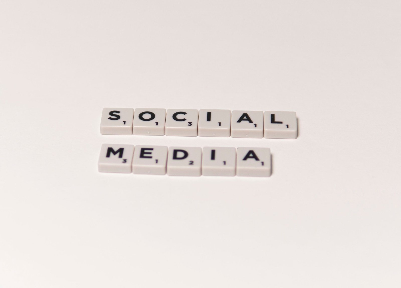 Scrabble tiles spelling 'social media' on a white background, representing digital communication concepts.